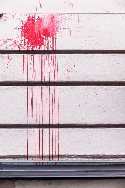 Rode inkt spatten op een muur — Stockfoto