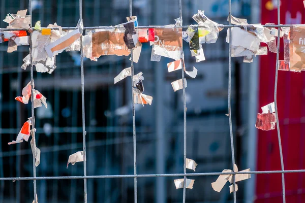 Kladjes papier tegen een hek draad — Stockfoto