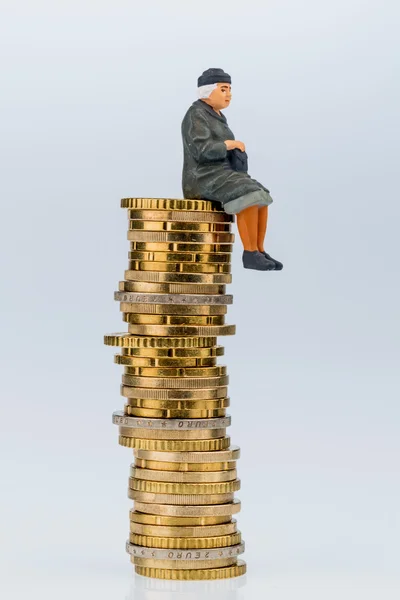 Pensioner sitting on money stack — Stock Photo, Image