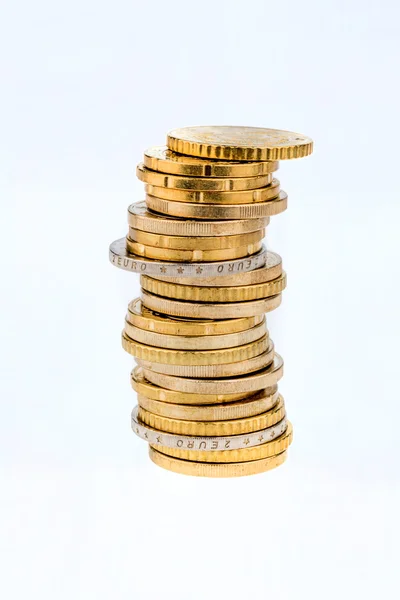 Pile di monete davanti uno sfondo bianco — Foto Stock