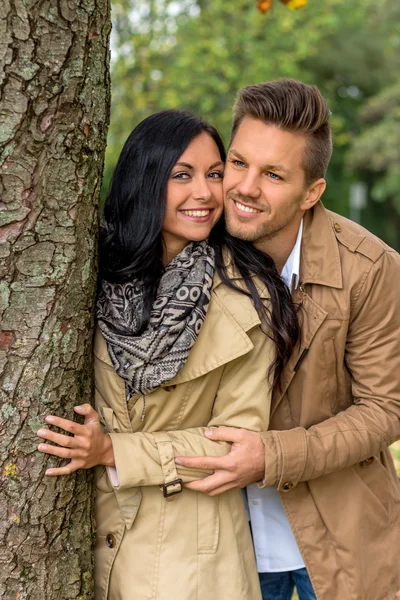 Pareja enamorada detrás de un árbol — Foto de Stock