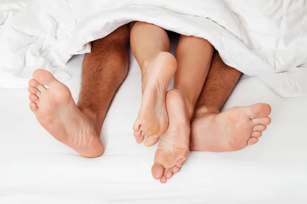 Feet of couple in bed. — Stock Photo, Image