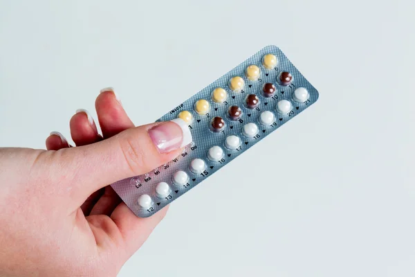 Hand taking birth control pills — Stock Photo, Image