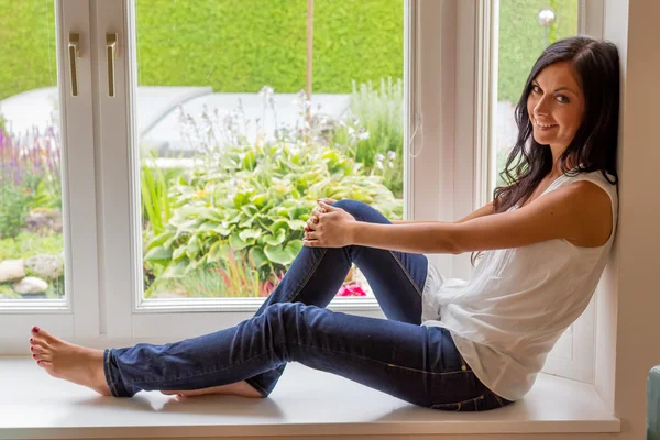 Vrouw zitten op venster — Stockfoto