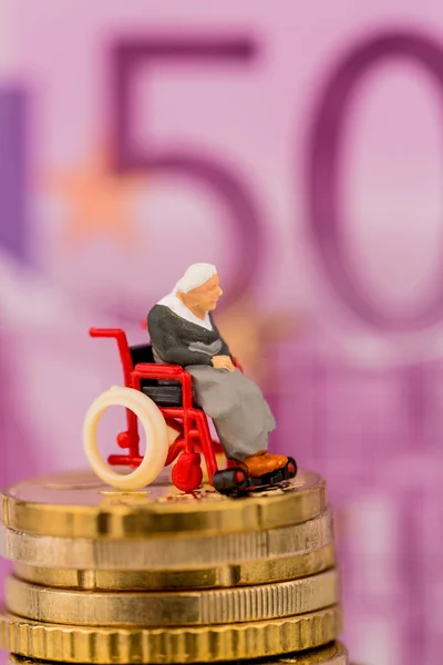 Woman in wheelchair on money stack — Stock Photo, Image