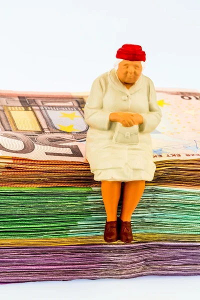 Senior sitting on banknotes — Stock Photo, Image