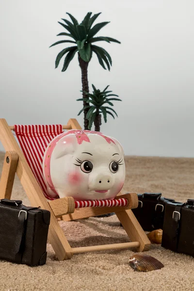 Piggy bank in een strandstoel — Stockfoto