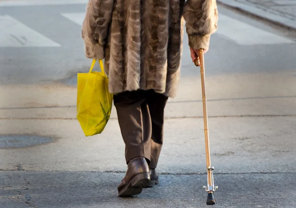 Vrouw met winkelen bag en wandelstok — Stockfoto