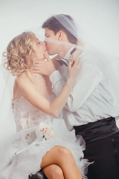 Par bruden och brudgummen täckt med slöja Royaltyfria Stockbilder