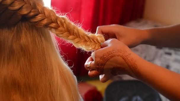 Primer plano de los brazos de un peluquero haciendo bastante trenza para una mujer . — Vídeos de Stock