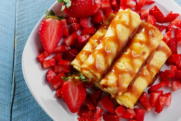 Panqueques enrollados con fresas y desayuno de caramelo — Foto de Stock