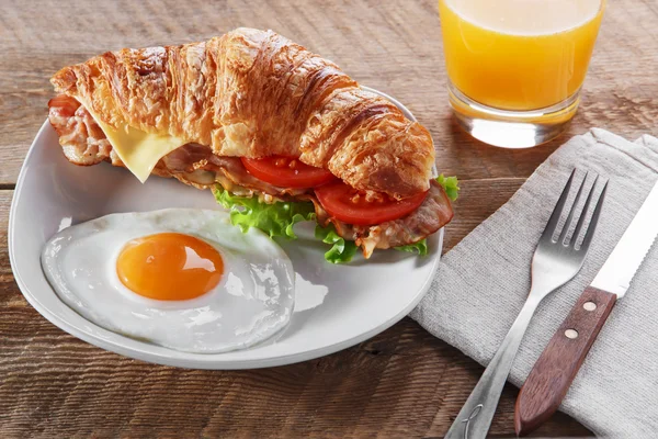 Sandwich croissant met gebakken spek kaas tomaat ontbijt en het ei — Stockfoto