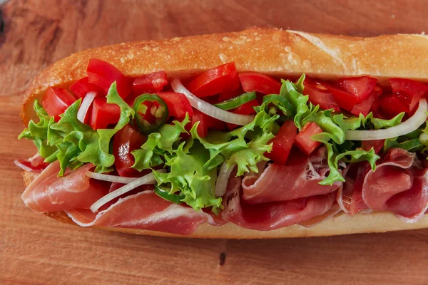 Szendvics baguette sonka Jamón paradicsommal és gyógynövények — Stock Fotó