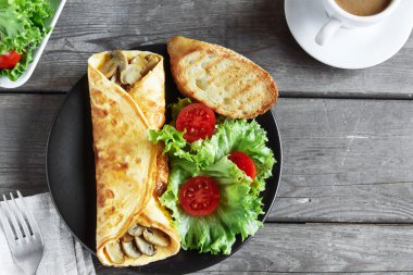 bir tabak salata ve domates ile mantarlı omlet