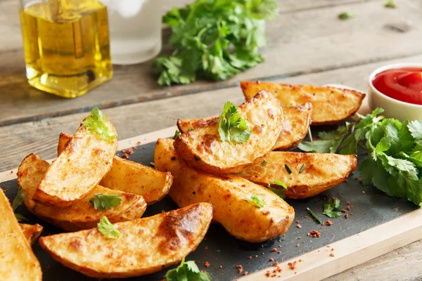 Fatias de batata assadas assadas com ervas e molho vermelho — Fotografia de Stock