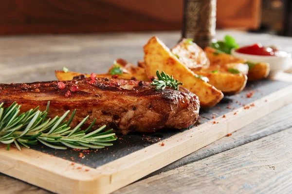 Bife no osso com batatas assadas — Fotografia de Stock