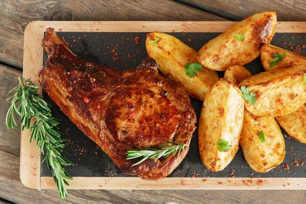 Steak op de bone met gebakken aardappelen — Stockfoto