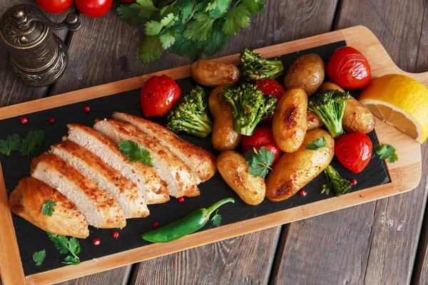 Kycklingbröst i ugn med tomat nya potatis och broccoli — Stockfoto