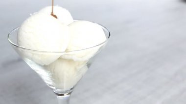 Beyaz dondurma topları sıvı karamel yağıyor