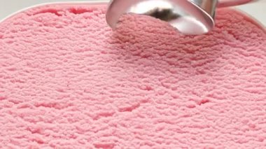 Çilekli dondurma konteyner kaşık dışarı scooped bir toptur