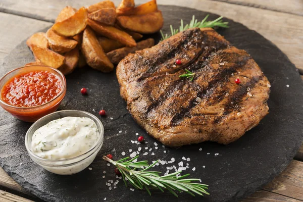 Bife de carne com batata assada e molho — Fotografia de Stock