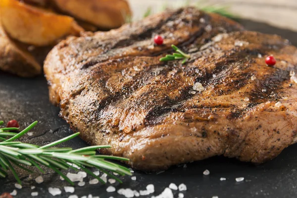 Beef steak with baked potato and sauce — Stock Photo, Image