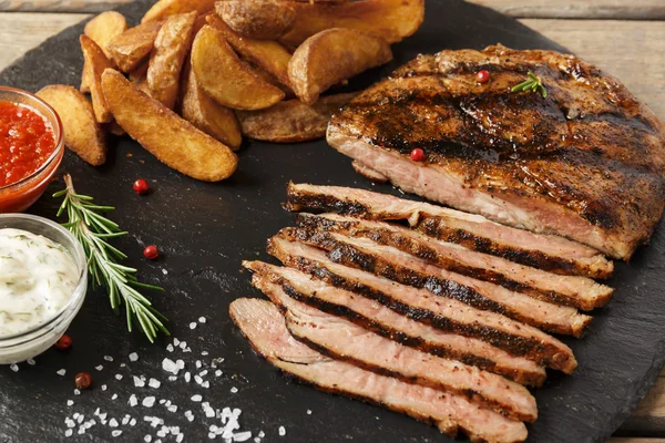 Bife de vaca fatiado com batata assada e molho — Fotografia de Stock