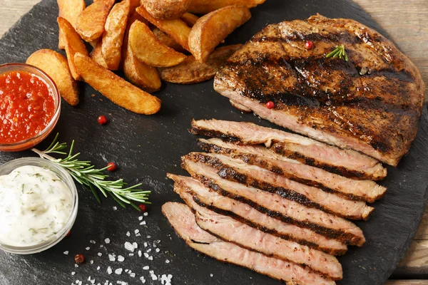 Bife de vaca fatiado com batata assada e molho — Fotografia de Stock