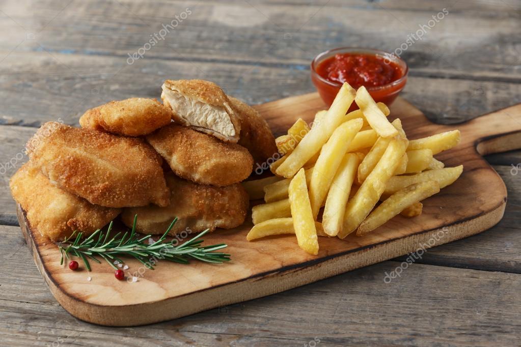 Chicken Nuggets Pommes frites auf dem Brett mit roter ...