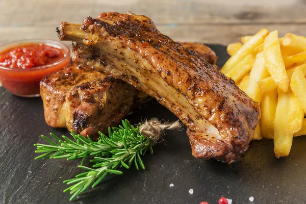 Gebackene Schweinerippchen mit Pommes und roter Soße — Stockfoto