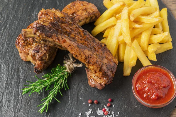 baked pork ribs with french fries and red sauce