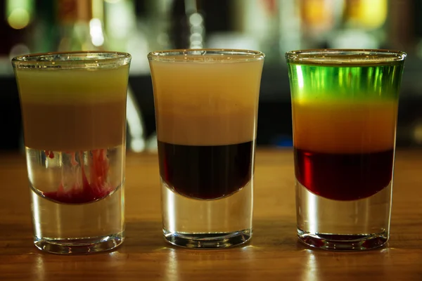 Varios diferentes bebidas alcohólicas disparos multicolores en la barra — Foto de Stock