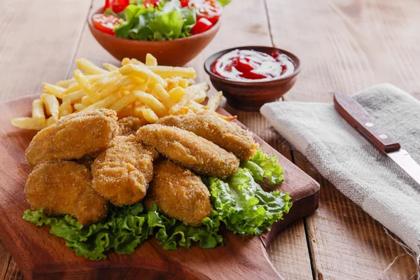 Asas de frango fritas em farinha de rosca com molho e batatas fritas — Fotografia de Stock