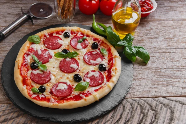 Pizza salam domates ve peynirle ahşap yüzeye