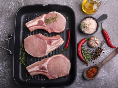 Taze çiğ et, et, kemik, ızgara tava, baharatlar.