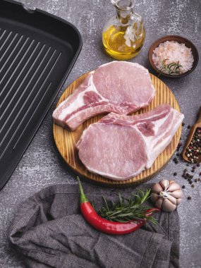 Taze çiğ et domuz eti, sığır eti, tahtada bir kemik, baharatlar, ızgara tava.
