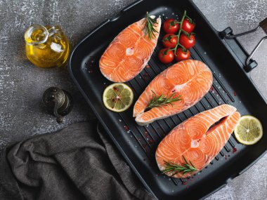 Üç çiğ balık balığı, somon balığı ve ızgara tavada baharat, koyu arka plan, üst manzara.