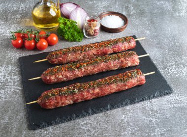 Siyah taştan bir yüzey üzerinde çiğ et kebabı, lula kebabı, yakın plan.
