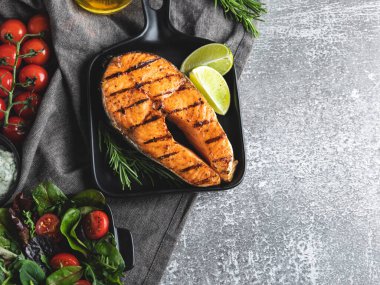 Izgara biftek, somon balığı, alabalık, baharatlar, taze salata, domates, yakın çekim, üst manzara.