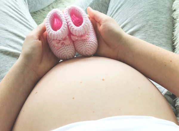 Nahaufnahme Einer Schwangeren Frau Mit Rosa Babybooties Auf Dem Bauch — Stockfoto