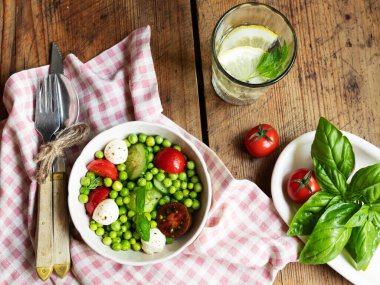 Salata vejetaryeni. Domates, salatalık, fesleğen, bezelye, mozzarella peynirli taze sebze salatası..