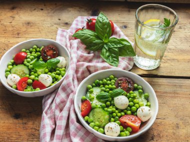 Salata vejetaryeni. Domates, salatalık, fesleğen, bezelye, mozzarella peynirli taze sebze salatası..