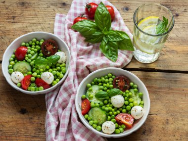 Salata vejetaryeni. Domates, salatalık, fesleğen, bezelye, mozzarella peynirli taze sebze salatası..