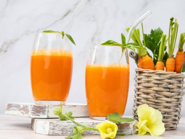 Taze sıkılmış havuç suyu, ahşap bir yüzeyde bardakta, kırsal tarzda sağlıklı beslenme, detoks, diyet ve vejetaryen konsepti..