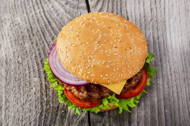 Hamburger ızgara et ve peynirle ahşap yüzeye