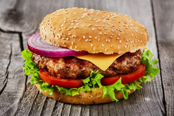 Hamburger, a sült hús és a sajt fafelületre — Stock Fotó