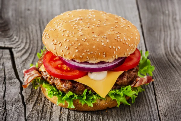 Hamburger, sült hús sajt szalonnával, fa felületre — Stock Fotó