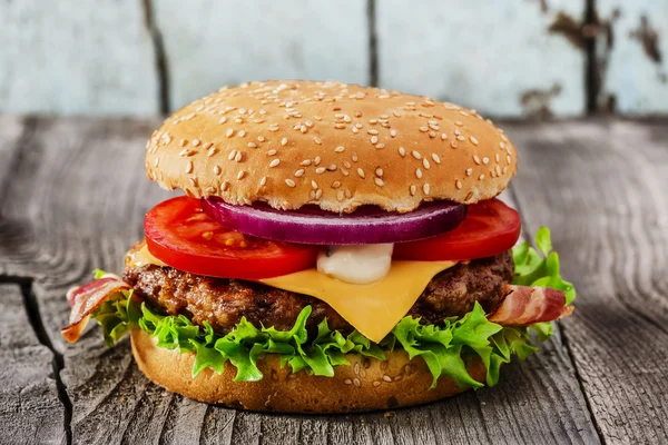 Hamburger, sült hús sajt szalonnával, fa felületre — Stock Fotó