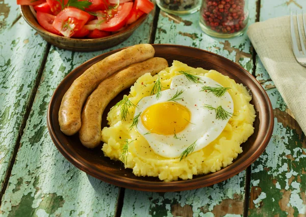 Mashed potatoes with fried egg and sausage — Stock Photo, Image