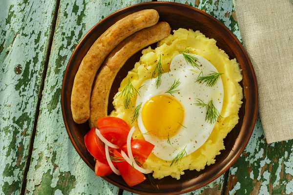 Mashed potatoes with fried egg and sausage — Stock Photo, Image